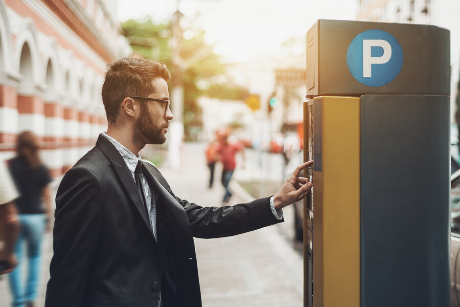 A man using a parking ticket machine