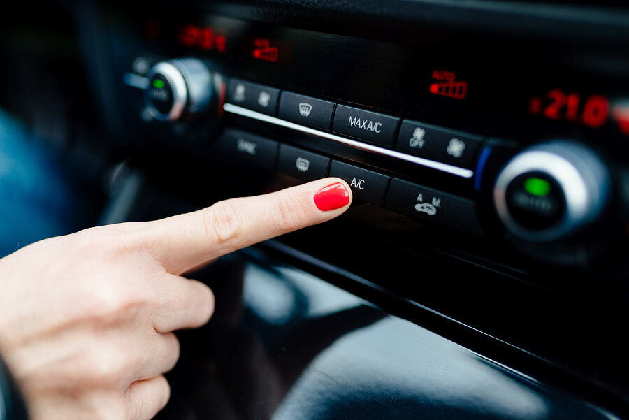 A person turning on their car's air conditioning